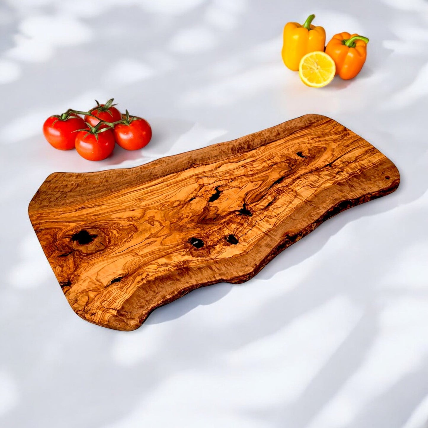 Large olive wood handcrafted charcuterie board with rustic, irregular shape, showcasing natural wood grain and artisanal craftsmanship.
