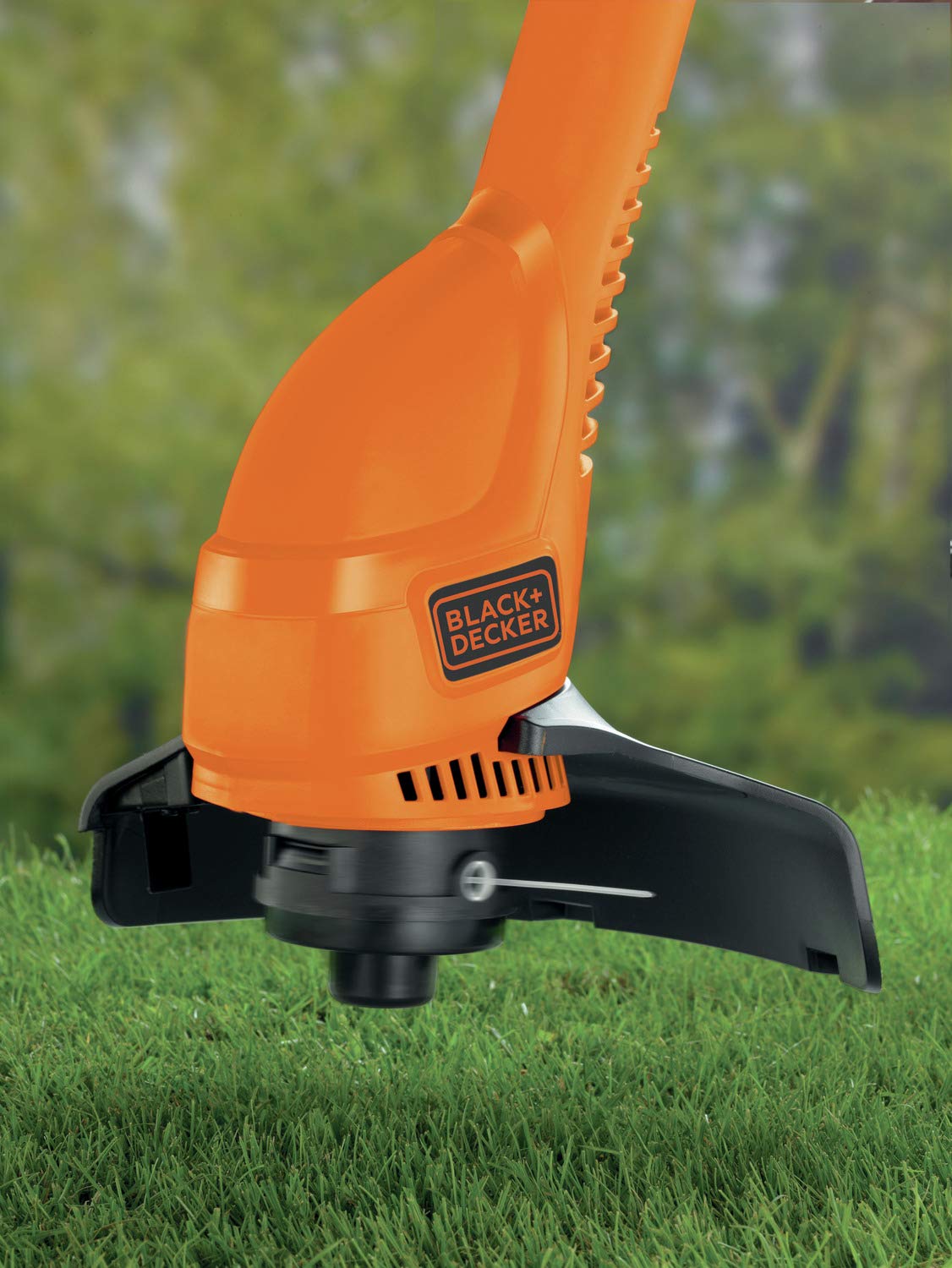 Black + Decker GL360 25cm manual lawn edger with 350W motor, shown in use trimming grass along a garden edge.