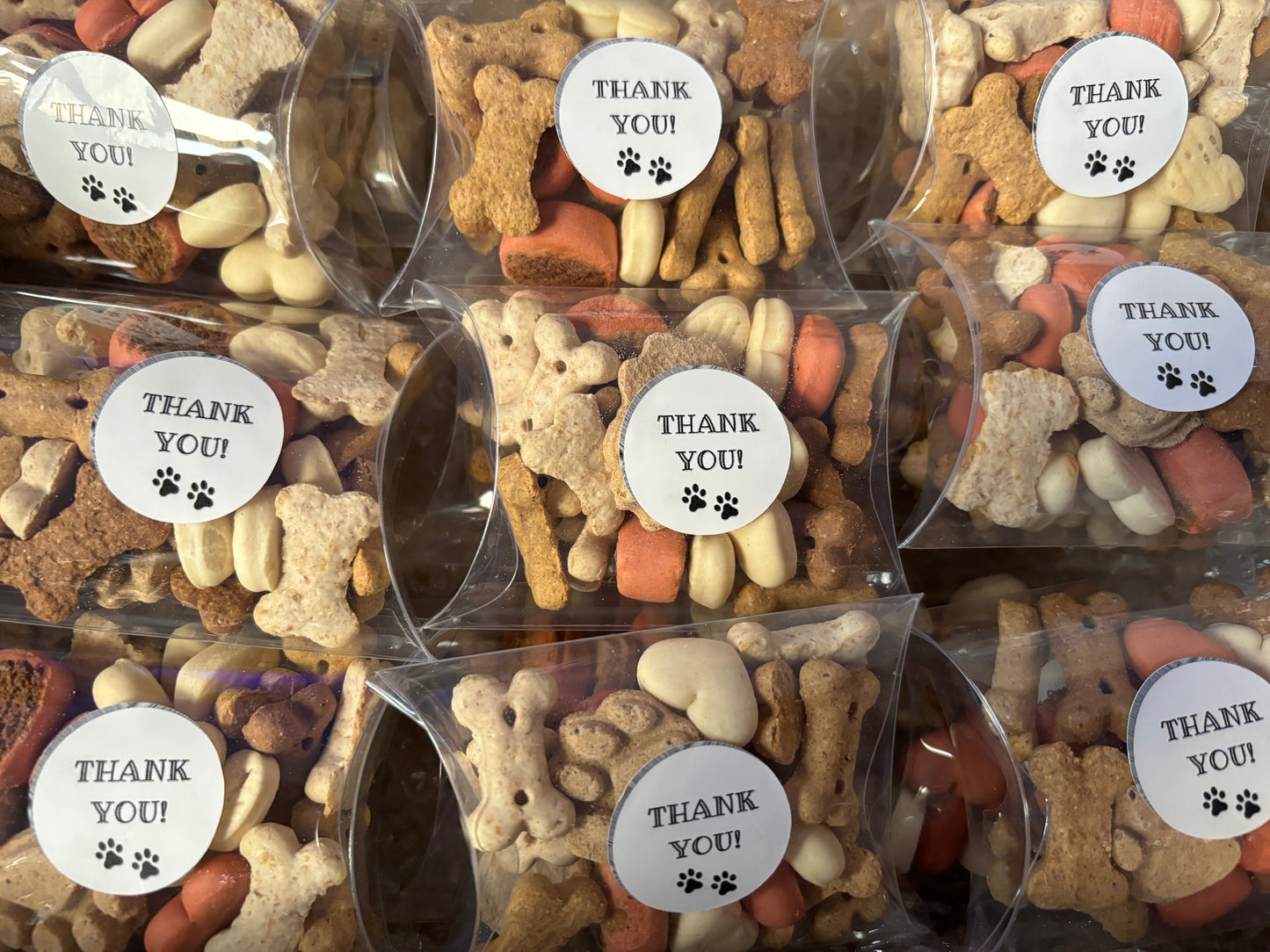 Assorted dog chocolate and biscuit treats in thank you gift boxes by The Bonnie Hound, displayed in colorful packaging