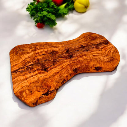 Large rustic handcrafted olive wood charcuterie board with an irregular shape, showcasing natural wood grain and artisanal craftsmanship.