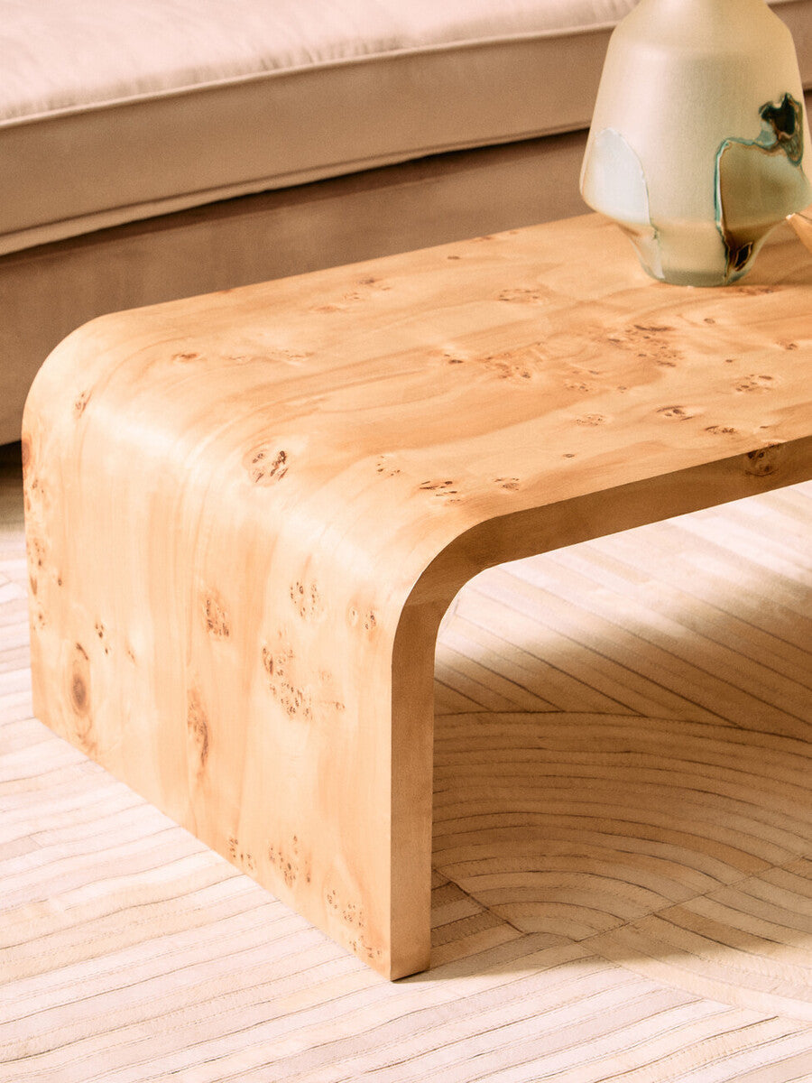 Natural burl wood curved coffee table with smooth edges from Orsina, showcasing a polished, organic design.