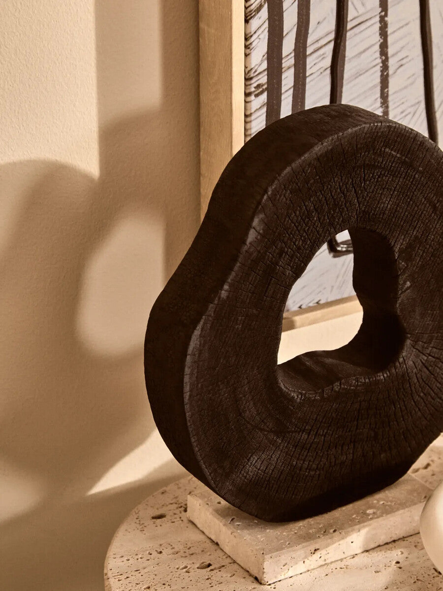 Orsina Tibor black mango wood sculpture with travertine base, modern art piece showcasing sleek wood and stone craftsmanship.