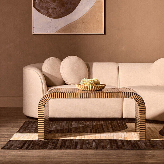 Natural finish curved coffee table by Orsina with striped bamboo inlay, showcasing smooth curves and textured bamboo details.