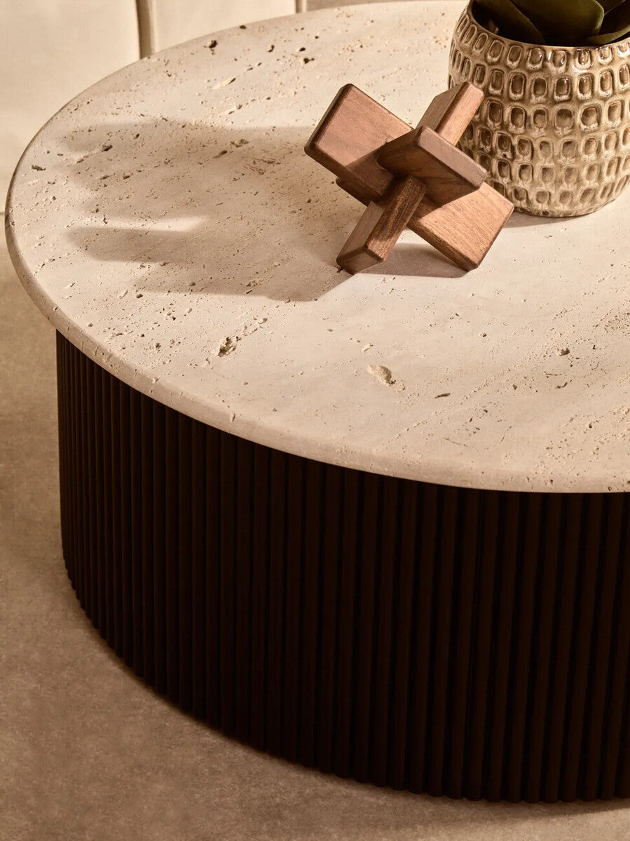 Cream polished travertine top coffee table with ridged black acacia wood drum base by Orsina, modern and stylish living room accent.