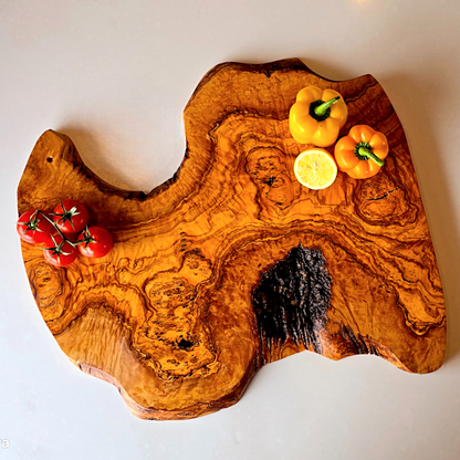 OliveArt handcrafted large rustic olive wood charcuterie board with irregular shape and natural wood grain detail.