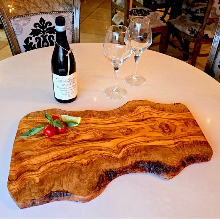 Rustic large olive wood handcrafted charcuterie board with irregular shape, ideal for serving cheese and meats.