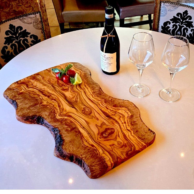 Large rustic olive wood charcuterie board with irregular shape, handcrafted by OliveArt for serving cheese and appetizers.