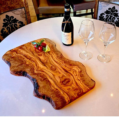 Large rustic olive wood charcuterie board with irregular shape, handcrafted by OliveArt for serving cheese and appetizers.