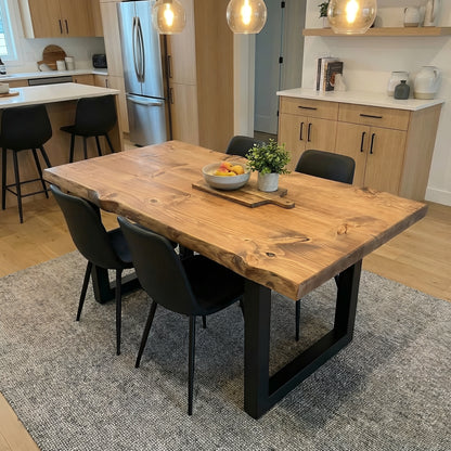 Waney edge wooden dining table with metal U-shaped legs by Tribe Joinery, showcasing natural wood grain and modern metal design.