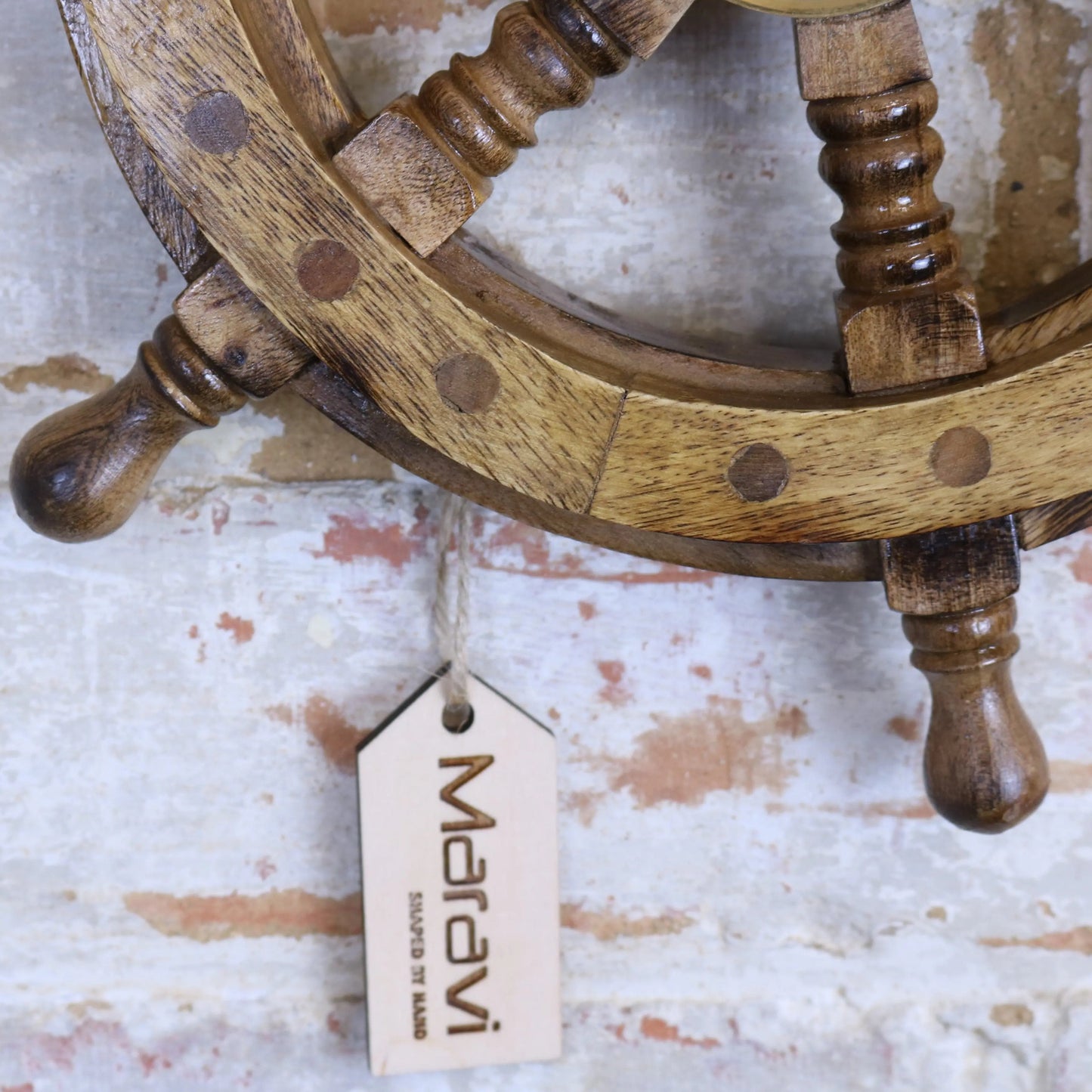 Natural-colored Naav wooden ships wheel ornament by Maravi, showcasing intricate craftsmanship and nautical design.
