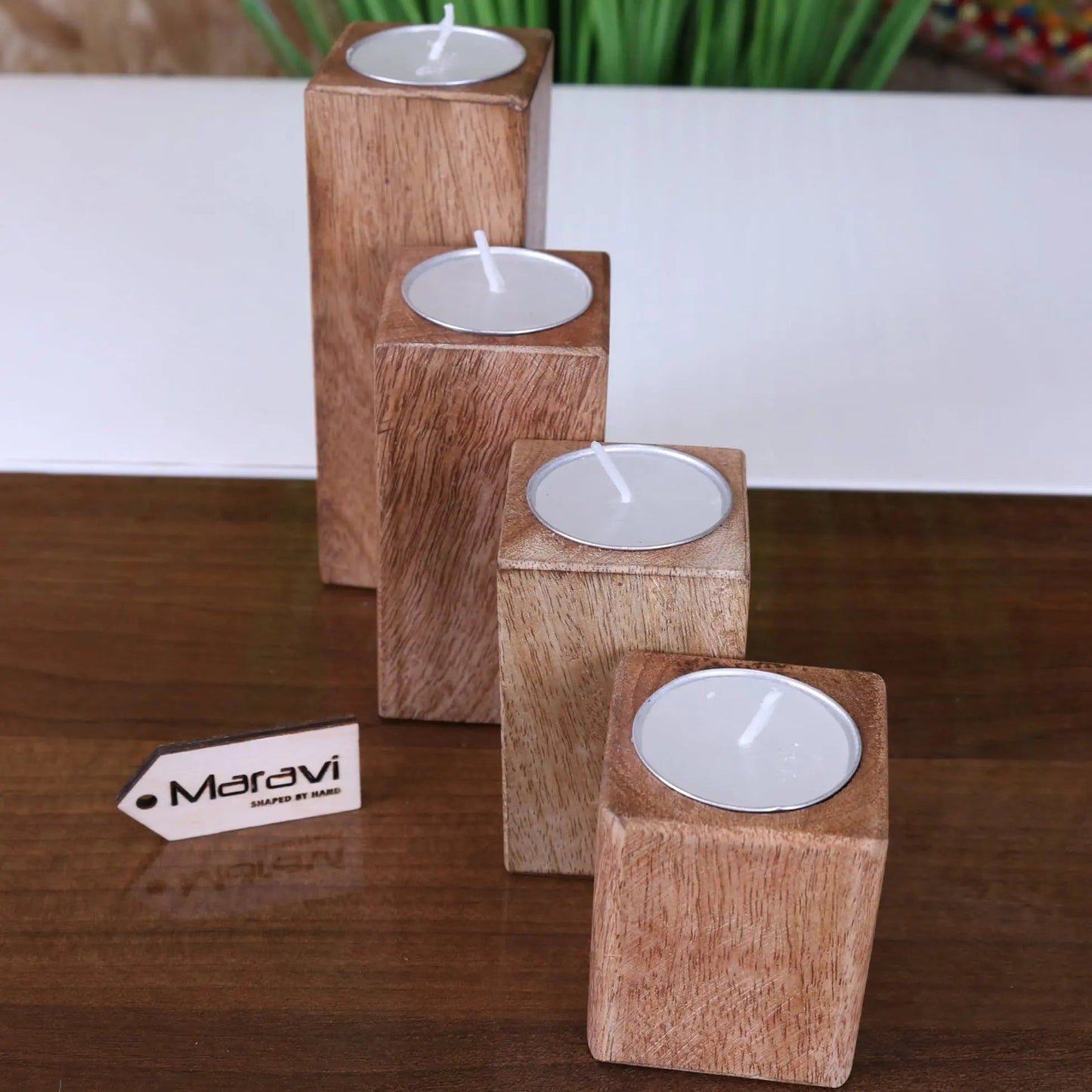 Set of four Bure wooden candle holders by Maravi, featuring natural wood finish and simple, elegant design for tea lights.