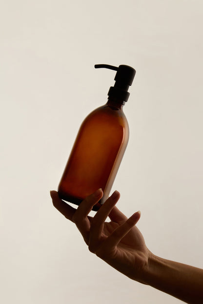 Amber glass soap dispenser with stainless steel pump by Kuishi, showcasing a sleek and stylish bathroom or kitchen accessory.