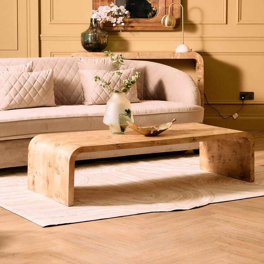 Natural burl wood curved coffee table with smooth edges by Orsina, showcasing a sleek, organic design and rich wood grain.