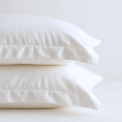 Set of organic cotton percale bed sheet pillowcases from Ethical Bedding™, featuring soft, breathable fabric and classic white design.