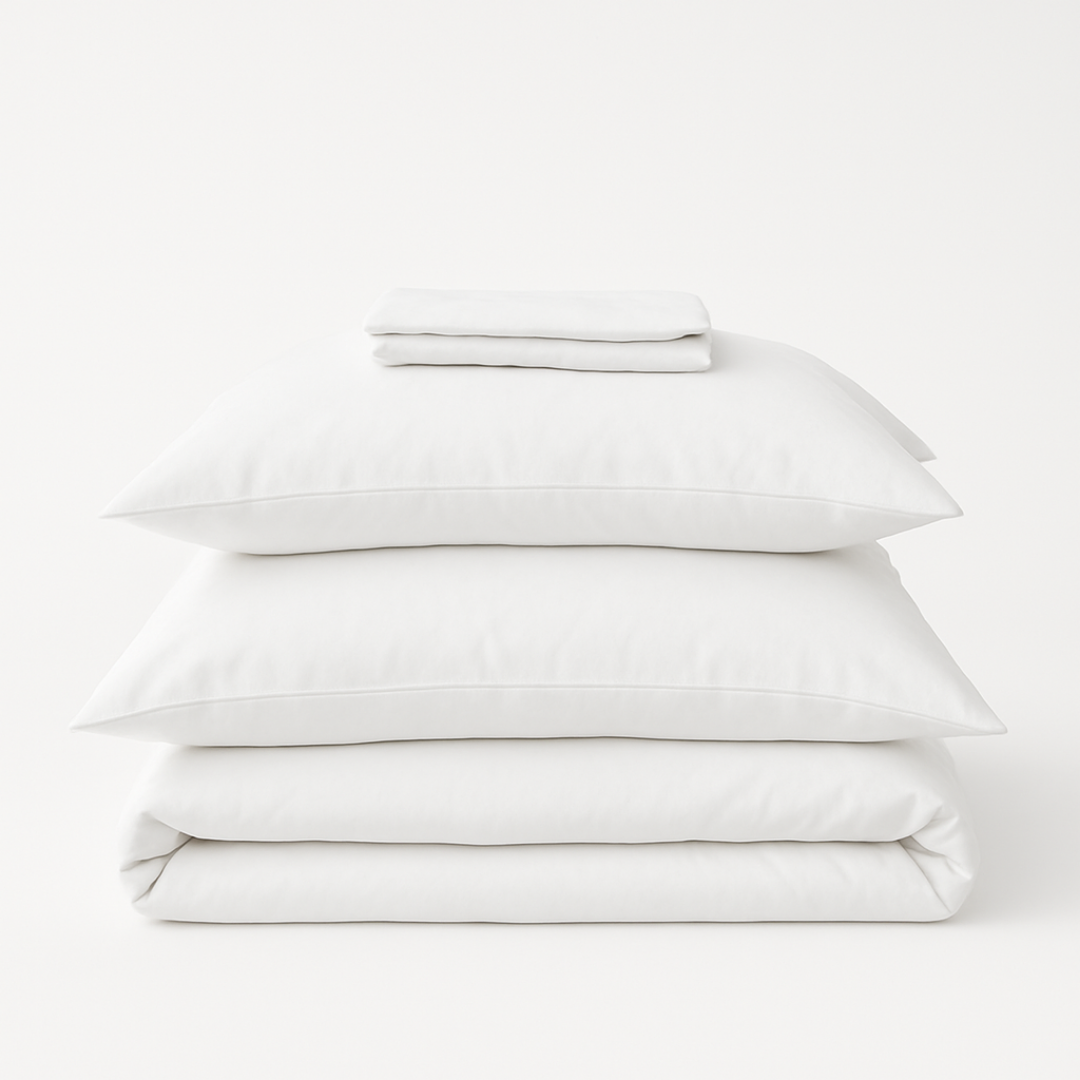 Organic cotton percale bed sheet set from Ethical Bedding™ with neatly folded, soft, white bed sheets and matching pillowcases.