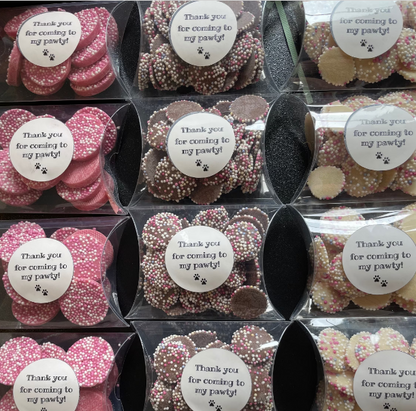 Assorted dog chocolate and biscuit treats in thank you boxes from The Bonnie Hound, featuring colorful paw print packaging.