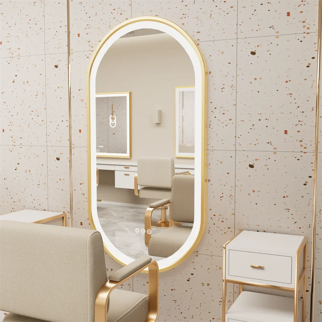 Large oval mirror with gold frame in a room with beige chairs and furniture.