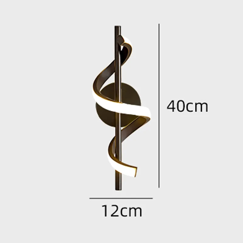 Black and gold Twisted LED wall light by Light My House mounted on a living room wall, modern design with a sleek, curved shape.