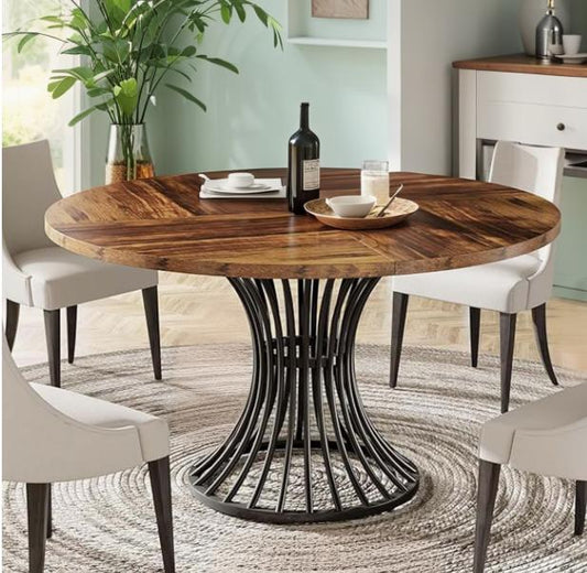 Dining table with wooden top and black metal base in a room with chairs and decor.