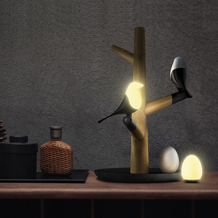 Lucky Bird LED night table lamp with wooden base, two birds and eggs, featuring motion sensor for living room or bedroom lighting.