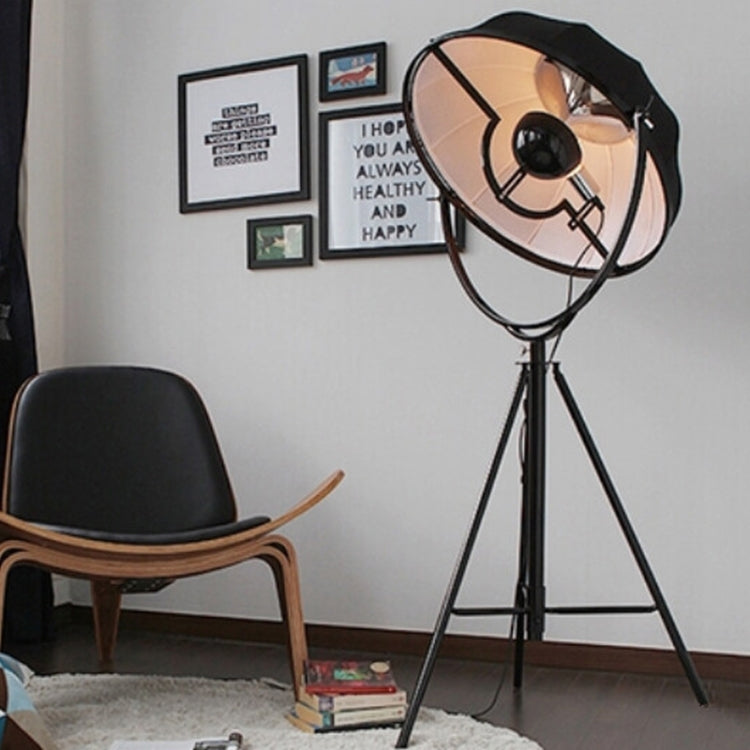 Industrial-style Satellite Studio Tripod Floor Lamp by Mira Sales, standing with adjustable tripod legs and a spotlight-style light.