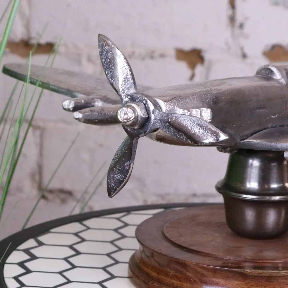 Vintage Spitfire model ornament by Maravi, made of metal, displayed on a wooden base, showcasing detailed aviation craftsmanship.
