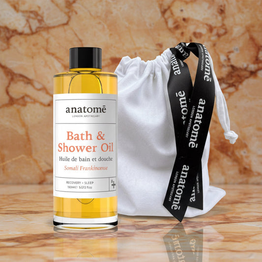 Anatomē Somali Frankincense Bath & Shower Oil bottle with a sleek design, featuring a white label and a silver cap.