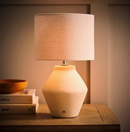 Finn ceramic rechargeable table lamp by TrendHomeDepot, portable wireless lamp emitting soft ambient light on a table.