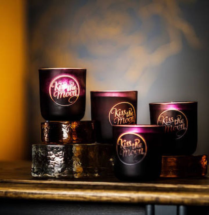 Aromatherapy soy candle by Kiss the Moon with a rose and frankincense scent, displayed in a glass jar for relaxation and rejuvenation.