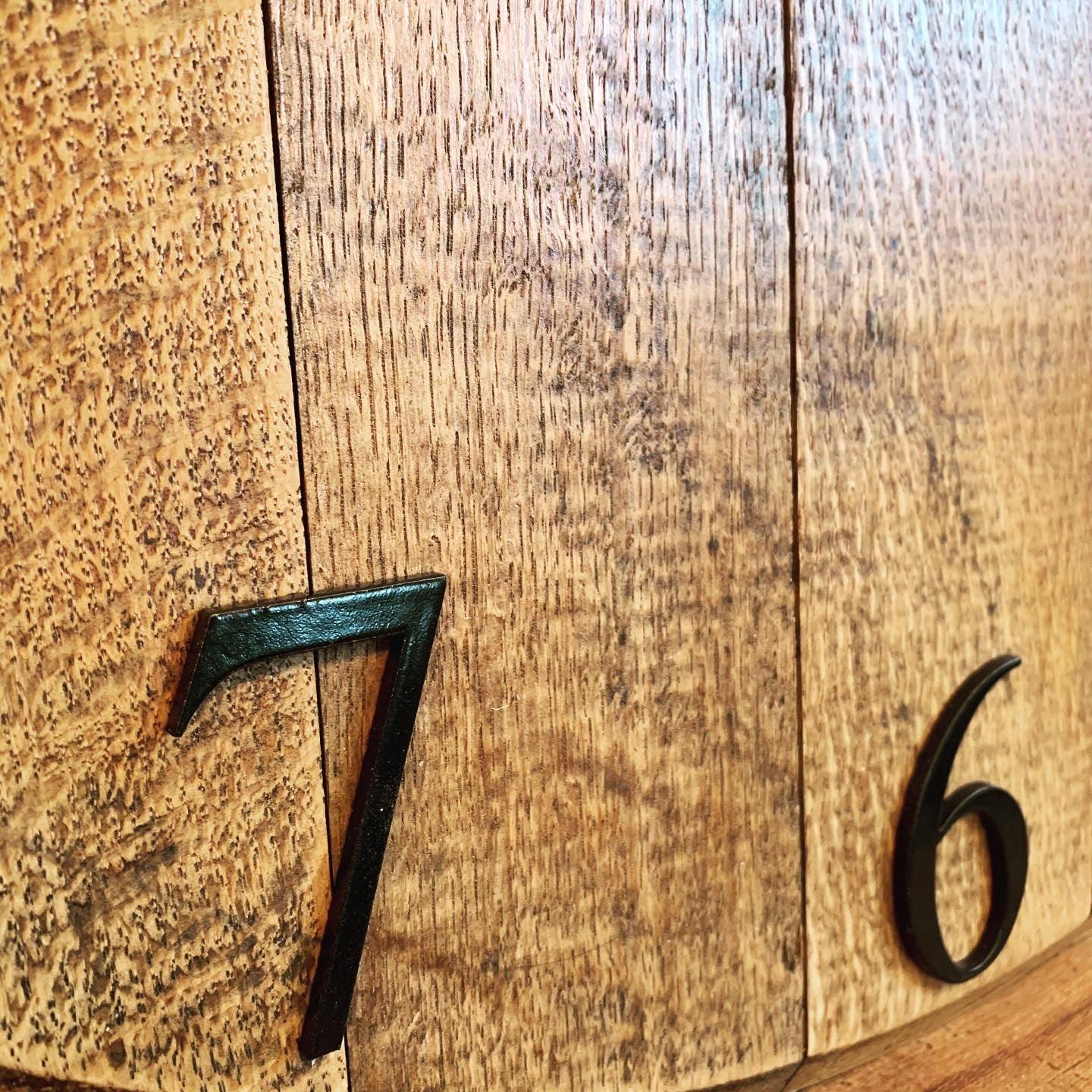 Oak finish whiskey barrel wall clock by MooBoo Home, made to order, showcasing a rustic design with visible wood grain and clock face.